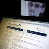A portrait of former U.S. spy agency contractor Edward Snowden is displayed behind a screen as he answers users' questions on Twitter in thi A portrait of former U.S. spy agency contractor Edward Snowden is displayed behind a screen as he answers users' questions on Twitter in thi