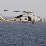 A Sikorsky SH-60 Seahawk helicopter flies near the Nimitz-class aircraft carrier USS Abraham Lincoln (CVN 72) during a transit through the S A Sikorsky SH-60 Seahawk helicopter flies near the Nimitz-class aircraft carrier USS Abraham Lincoln (CVN 72) during a transit through the S