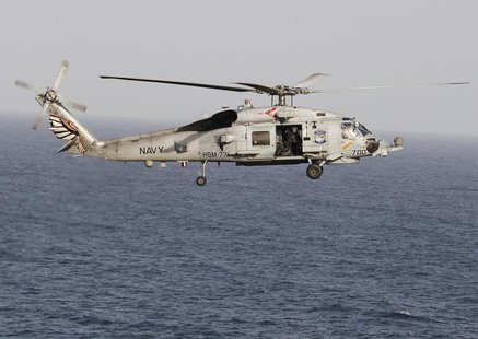 A Sikorsky SH-60 Seahawk helicopter flies near the Nimitz-class aircraft carrier USS Abraham Lincoln (CVN 72) during a transit through the S A Sikorsky SH-60 Seahawk helicopter flies near the Nimitz-class aircraft carrier USS Abraham Lincoln (CVN 72) during a transit through the S