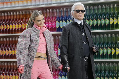 German designer Karl Lagerfeld (R) and model Cara Delevingne appear at the end of his Fall/Winter 2014-2015 women's ready-to-wear collection German designer Karl Lagerfeld (R) and model Cara Delevingne appear at the end of his Fall/Winter 2014-2015 women's ready-to-wear collection