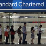 People queue up outside a Standard Chartered Bank branch before operation hours at the central business district in Singapore January 23, 20 People queue up outside a Standard Chartered Bank branch before operation hours at the central business district in Singapore January 23, 20