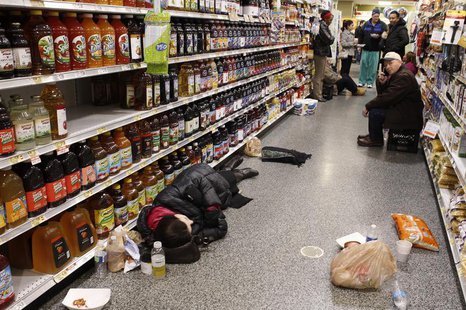 People rest at the aisle of a Publix grocery store after being stranded due to a snow storm in Atlanta, Georgia, January 29, 2014. REUTERS/T People rest at the aisle of a Publix grocery store after being stranded due to a snow storm in Atlanta, Georgia, January 29, 2014. REUTERS/T