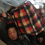 A man carries his luggage on his shoulder at a railway station in Beijing January 14, 2014. REUTERS/China Daily A man carries his luggage on his shoulder at a railway station in Beijing January 14, 2014. REUTERS/China Daily