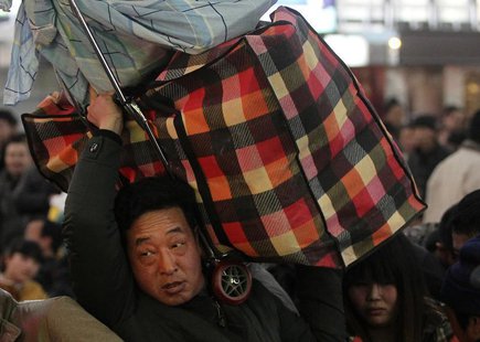 A man carries his luggage on his shoulder at a railway station in Beijing January 14, 2014. REUTERS/China Daily A man carries his luggage on his shoulder at a railway station in Beijing January 14, 2014. REUTERS/China Daily