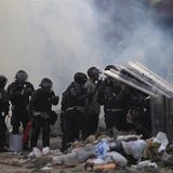 Riot police take cover from stones throw by anti-government protesters during a protest against the government of Venezuela's President Nico Riot police take cover from stones throw by anti-government protesters during a protest against the government of Venezuela's President Nico