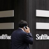 A man using a mobile phone walks past a SoftBank Corp branch in Tokyo May 29, 2013. REUTERS/Toru Hanai A man using a mobile phone walks past a SoftBank Corp branch in Tokyo May 29, 2013. REUTERS/Toru Hanai