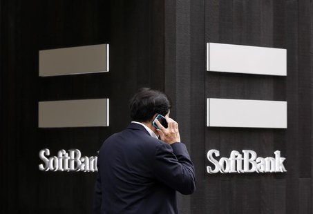A man using a mobile phone walks past a SoftBank Corp branch in Tokyo May 29, 2013. REUTERS/Toru Hanai A man using a mobile phone walks past a SoftBank Corp branch in Tokyo May 29, 2013. REUTERS/Toru Hanai