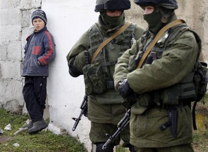 A boy looks at uniformed men, believed to be Russian servicemen, near a Ukrainian military base in the village of Perevalnoye, outside Simferopol, March 6, 2014.
CREDIT: REUTERS/VASILY FEDOSENKO A boy looks at uniformed men, believed to be Russian servicemen, near a Ukrainian military base in the village of Perevalnoye, outside Simferopol, March 6, 2014.
CREDIT: REUTERS/VASILY FEDOSENKO