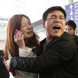A relative (woman in white) of a passenger onboard Malaysia Airlines flight MH370 cries as she talks on her mobile phone at the Beijing Capital International Airport March 8, 2014.
Credit: REUTERS/Kim Kyung-Hoon A relative (woman in white) of a passenger onboard Malaysia Airlines flight MH370 cries as she talks on her mobile phone at the Beijing Capital International Airport March 8, 2014.
Credit: REUTERS/Kim Kyung-Hoon