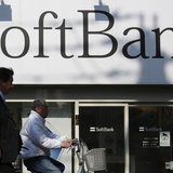 Pedestrians walk in front of a SoftBank Corp logo outside its branch in Tokyo February 25, 2014.REUTERS/Yuya Shino Pedestrians walk in front of a SoftBank Corp logo outside its branch in Tokyo February 25, 2014.REUTERS/Yuya Shino