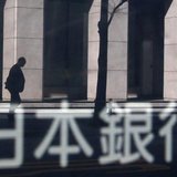 A man walking past a building is reflected in a sign board of the Bank of Japan building in Tokyo January 22, 2014. REUTERS/Yuya Shino A man walking past a building is reflected in a sign board of the Bank of Japan building in Tokyo January 22, 2014. REUTERS/Yuya Shino