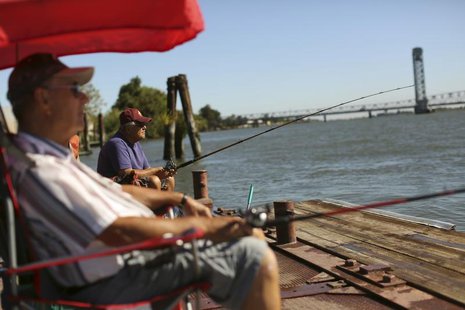 Retirees Gene Bloczynski (L) and Eric Vannieuwburg fish from a public dock on the Sacramento River in the Sacramento San Joaquin River Delta Retirees Gene Bloczynski (L) and Eric Vannieuwburg fish from a public dock on the Sacramento River in the Sacramento San Joaquin River Delta