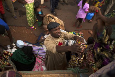 Father Bernard Kenvi (C) helps a Muslim child climb down from an open truck in the town of Bossemptele, west of Central African Republic Mar Father Bernard Kenvi (C) helps a Muslim child climb down from an open truck in the town of Bossemptele, west of Central African Republic Mar