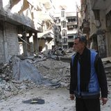 A man stands amid the rubble of damaged buildings at the Palestinian refugee camp of Yarmouk, south of Damascus February 18, 2014. REUTERS/S A man stands amid the rubble of damaged buildings at the Palestinian refugee camp of Yarmouk, south of Damascus February 18, 2014. REUTERS/S