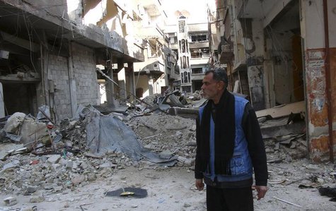 A man stands amid the rubble of damaged buildings at the Palestinian refugee camp of Yarmouk, south of Damascus February 18, 2014. REUTERS/S A man stands amid the rubble of damaged buildings at the Palestinian refugee camp of Yarmouk, south of Damascus February 18, 2014. REUTERS/S