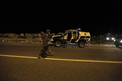 An Israeli soldier walks near the scene where a Palestinian was shot dead near the West Bank city of Ramallah March 10, 2014. REUTERS/Ammar An Israeli soldier walks near the scene where a Palestinian was shot dead near the West Bank city of Ramallah March 10, 2014. REUTERS/Ammar