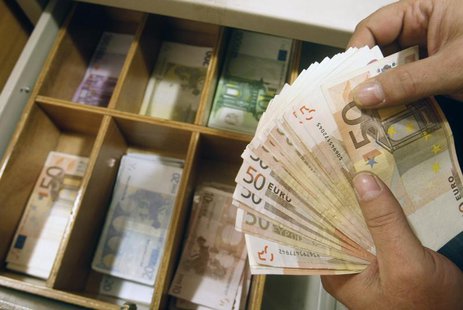 A teller counts euro banknotes inside a National Bank of Greece branch in Athens February 10, 2010. REUTERS/John Kolesidis A teller counts euro banknotes inside a National Bank of Greece branch in Athens February 10, 2010. REUTERS/John Kolesidis