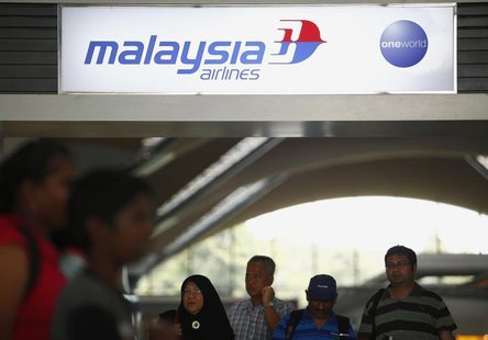 People walk under a Malaysia Airlines sign at Kuala Lumpur International Airport in Sepang March 8, 2014. REUTERS/Samsul Said People walk under a Malaysia Airlines sign at Kuala Lumpur International Airport in Sepang March 8, 2014. REUTERS/Samsul Said