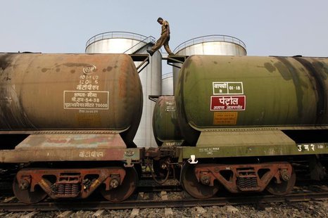 A worker walks atop a tanker wagon to check the freight level at an oil terminal on the outskirts of Kolkata November 27, 2013. REUTERS/Rupa A worker walks atop a tanker wagon to check the freight level at an oil terminal on the outskirts of Kolkata November 27, 2013. REUTERS/Rupa