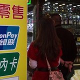 Chinese visitors walk past a sign for China UnionPay outside a pawnshop in Macau, in this picture taken November 20, 2013. REUTERS/Tyrone Si Chinese visitors walk past a sign for China UnionPay outside a pawnshop in Macau, in this picture taken November 20, 2013. REUTERS/Tyrone Si