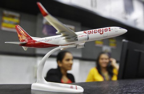 Employees work inside a travel agency office besides a model of a SpiceJet aircraft in the western Indian city of Ahmedabad February 14, 201 Employees work inside a travel agency office besides a model of a SpiceJet aircraft in the western Indian city of Ahmedabad February 14, 201