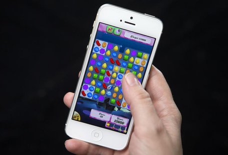 A woman poses for a photo illustration with an iPhone as she plays Candy Crush in New York February 18, 2014. REUTERS/Carlo Allegri A woman poses for a photo illustration with an iPhone as she plays Candy Crush in New York February 18, 2014. REUTERS/Carlo Allegri
