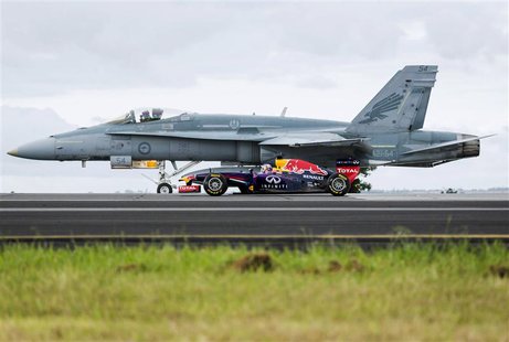 Formula One driver Daniel Ricciardo of Australia drives his Infiniti Red Bull car alongside a Royal Australian Air Force F/A-18 Hornet plane Formula One driver Daniel Ricciardo of Australia drives his Infiniti Red Bull car alongside a Royal Australian Air Force F/A-18 Hornet plane