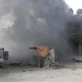 Men walk at a site hit by what activists said were barrel bombs dropped by forces loyal to Syria's President Bashar al-Assad in Aleppo's al- Men walk at a site hit by what activists said were barrel bombs dropped by forces loyal to Syria's President Bashar al-Assad in Aleppo's al-