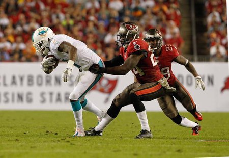 Nov 11, 2013; Tampa, FL, USA; Tampa Bay Buccaneers cornerback Darrelle Revis (24) tackles Miami Dolphins wide receiver Mike Wallace (11) dur Nov 11, 2013; Tampa, FL, USA; Tampa Bay Buccaneers cornerback Darrelle Revis (24) tackles Miami Dolphins wide receiver Mike Wallace (11) dur