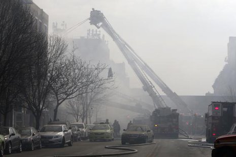 Fire fighters on East 116th street pour water on an apparent building explosion fire and collapse in the Harlem section of New York City, March 12, 2014.
CREDIT: REUTERS/MIKE SEGAR Fire fighters on East 116th street pour water on an apparent building explosion fire and collapse in the Harlem section of New York City, March 12, 2014.
CREDIT: REUTERS/MIKE SEGAR