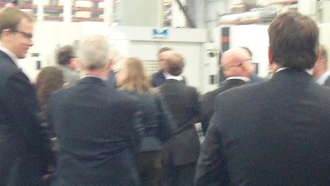 Calley and the other conferees huddle around a plastic injection mold during the tour. Calley and the other conferees huddle around a plastic injection mold during the tour.