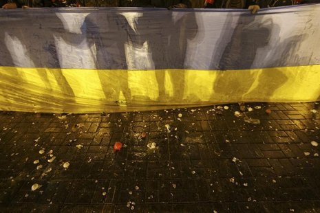 Participants of an anti-war rally hold a national flag as eggs thrown by pro-Russia protesters cover the floor during their clashes in Donet Participants of an anti-war rally hold a national flag as eggs thrown by pro-Russia protesters cover the floor during their clashes in Donet