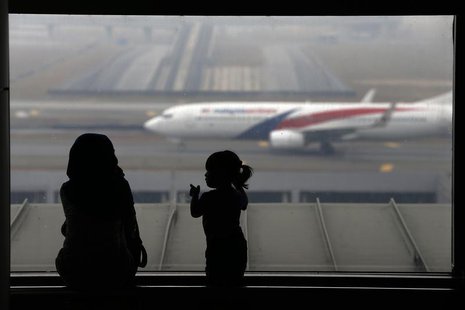 A woman and a girl look at a Malaysia Airlines plane on the tarmac of Kuala Lumpur International Airport March 13, 2014. REUTERS/Damir Sagol A woman and a girl look at a Malaysia Airlines plane on the tarmac of Kuala Lumpur International Airport March 13, 2014. REUTERS/Damir Sagol