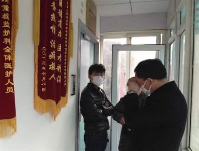 Friends of human right activist Cao Shunli stand in front of an intensive care unit where Cao is hospitalized as they are not allowed to go Friends of human right activist Cao Shunli stand in front of an intensive care unit where Cao is hospitalized as they are not allowed to go
