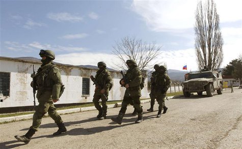 Armed men, believed to be Russian servicemen, walk outside a Ukrainian military base in Perevalnoye, near the Crimean city of Simferopol, Ma Armed men, believed to be Russian servicemen, walk outside a Ukrainian military base in Perevalnoye, near the Crimean city of Simferopol, Ma
