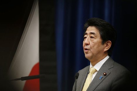 Japan's Prime Minister Shinzo Abe speaks next to the Japanese national flag, attached with a black ribbon to mourn victims during a news con Japan's Prime Minister Shinzo Abe speaks next to the Japanese national flag, attached with a black ribbon to mourn victims during a news con