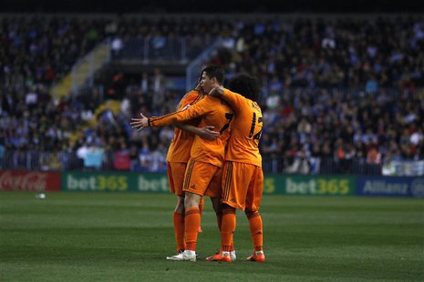 Real Madrid's Cristiano Ronaldo (C) is congratulated by his teammates after scoring a goal against Malaga during their Spanish First Divisio Real Madrid's Cristiano Ronaldo (C) is congratulated by his teammates after scoring a goal against Malaga during their Spanish First Divisio