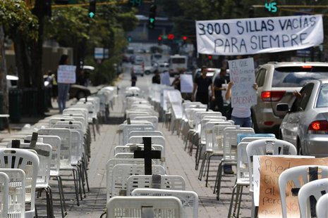 Anti-government protesters placed black crosses on white chairs, representing victims who died from violence, during a demonstration in Cara Anti-government protesters placed black crosses on white chairs, representing victims who died from violence, during a demonstration in Cara