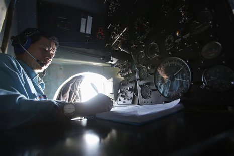 Senior Lieutenant Phung Truong Son takes notes while working within the cockpit of a Vietnam Air Force AN-26 aircraft during a mission to fi Senior Lieutenant Phung Truong Son takes notes while working within the cockpit of a Vietnam Air Force AN-26 aircraft during a mission to fi