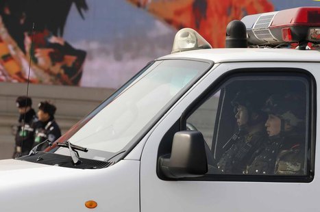 Paramilitary policemen (R) keep watch from a van as police officers (back L) stand guard at Tiananmen Square near the Great Hall of the Peop Paramilitary policemen (R) keep watch from a van as police officers (back L) stand guard at Tiananmen Square near the Great Hall of the Peop