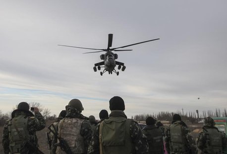 A Russian army MI-35 military helicopter patrols the area as Ukrainian servicemen guard a checkpoint near the village of Strelkovo in Kherso A Russian army MI-35 military helicopter patrols the area as Ukrainian servicemen guard a checkpoint near the village of Strelkovo in Kherso
