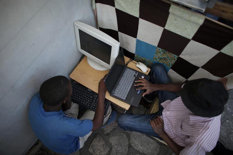 A resident reads emails at a makeshift internet cafe in front of the presidential palace in Port-au-Prince, Haiti January 30, 2010. REUTERS/ A resident reads emails at a makeshift internet cafe in front of the presidential palace in Port-au-Prince, Haiti January 30, 2010. REUTERS/