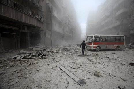A man inspects the damage at a site hit by what activists said were barrel bombs dropped by forces loyal to Syria's President Bashar al-Assa A man inspects the damage at a site hit by what activists said were barrel bombs dropped by forces loyal to Syria's President Bashar al-Assa