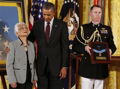 U.S. President Barack Obama (C) holds Alice Mendoza (L), before awarding her husband, Staff Sgt. Manuel Mendoza (not pictured), the Medal of U.S. President Barack Obama (C) holds Alice Mendoza (L), before awarding her husband, Staff Sgt. Manuel Mendoza (not pictured), the Medal of