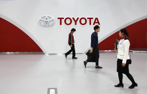 Employees and a customer (C) walk in front of Toyota Motor's logo at the company's showroom in Tokyo March 12, 2014. REUTERS/Toru Hanai Employees and a customer (C) walk in front of Toyota Motor's logo at the company's showroom in Tokyo March 12, 2014. REUTERS/Toru Hanai