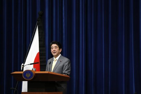 Japan's Prime Minister Shinzo Abe speaks next to the Japanese national flag, attached with a black ribbon to mourn victims during a news con Japan's Prime Minister Shinzo Abe speaks next to the Japanese national flag, attached with a black ribbon to mourn victims during a news con