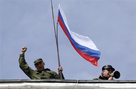 A man holds a Russian flag on the roof of the naval headquarters in Sevastopol, March 19, 2014. REUTERS/Vasily Fedosenko A man holds a Russian flag on the roof of the naval headquarters in Sevastopol, March 19, 2014. REUTERS/Vasily Fedosenko