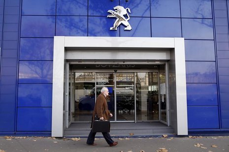 A man walks in front of a Peugeot automobile dealership in Paris December 13, 2013. REUTERS/Charles Platiau A man walks in front of a Peugeot automobile dealership in Paris December 13, 2013. REUTERS/Charles Platiau