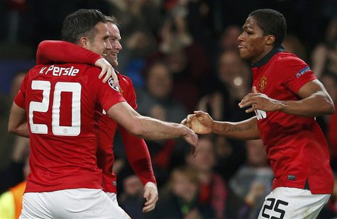Manchester United's Robin van Persie (L) celebrates with Wayne Rooney and Antonio Valencia (R) a second goal against Olympiakos during their Manchester United's Robin van Persie (L) celebrates with Wayne Rooney and Antonio Valencia (R) a second goal against Olympiakos during their