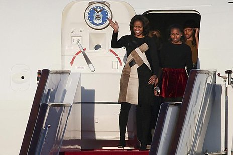 U.S. first lady Michelle Obama (L) waves as she walks out the plane with her daughters Sasha (2nd R) and Malia (R) upon their arrival at Bei U.S. first lady Michelle Obama (L) waves as she walks out the plane with her daughters Sasha (2nd R) and Malia (R) upon their arrival at Bei